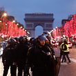 TOPSHOT - French riot police officers stand in the centre of the Champs Elysee thoroughfare as "Yellow vest" (gilets jaunes) anti-government demonstrators gather in central Paris on December 29, 2018. - Police fired tear gas at "yellow vest" demonstrators in Paris on December 29 but the turnout for round seven of the popular protests that have rocked France appeared low. The yellow vests (gilets jaunes) movement in France originally started as a protest about planned fuel hikes but has morphed into a mass protest against President's policies and top-down style of governing. (Photo by Sameer Al-Doumy / AFP)