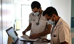 A doctor checks documents in a corridor of the infectious diseases unit of the Gonesse hospital before visiting a patient in Gonesse, north of Paris, on October 22, 2020. - The hospital of Gonesse welcomed 68 Covid patients on October 22. This is far from the 150 in the spring, but well above the 40 patients a week earlier. "We can see the rise accelerating," worries Jean Pinson, the hospital director. (Photo by Christophe ARCHAMBAULT / AFP)