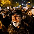 TOPSHOT - Protesters march along a street during a rally for the victims of a deadly fire as well as a protest against China's harsh Covid-19 restrictions in Beijing on November 28, 2022. - A deadly fire on November 24, 2022 in Urumqi, the capital of northwest China's Xinjiang region, has become a fresh catalyst for public anger, with many blaming Covid lockdowns for hampering rescue efforts, as hundreds of people took to the streets in China's major cities on November 27, 2022 to protest against the country's zero-Covid policy in a rare outpouring of public anger against the state. Authorities deny the claims. (Photo by Noel CELIS / AFP)