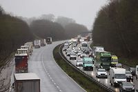 Freight lorries are organised into stacks (L) by police on the M20 motorway which leads to the Port of Dover at Mersham in Kent, south east England on December 21, 2020, as a string of countries banned travel including accompanied freight arriving from the UK, due to the rapid spread of a more-infectious new coronavirus strain. - Britain's critical south coast port at Dover said on Sunday it was closing to all accompanied freight and passengers due to the French border restrictions "until further notice". (Photo by Adrian DENNIS / AFP)