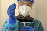 A health worker wearing PPE (Personal protective equipment) processes a quick test for the coronavirus (Covid-19) at a test centre in Herrsching, southern Germany, on July 5, 2021, amid the pandemic. (Photo by Christof STACHE / AFP)
