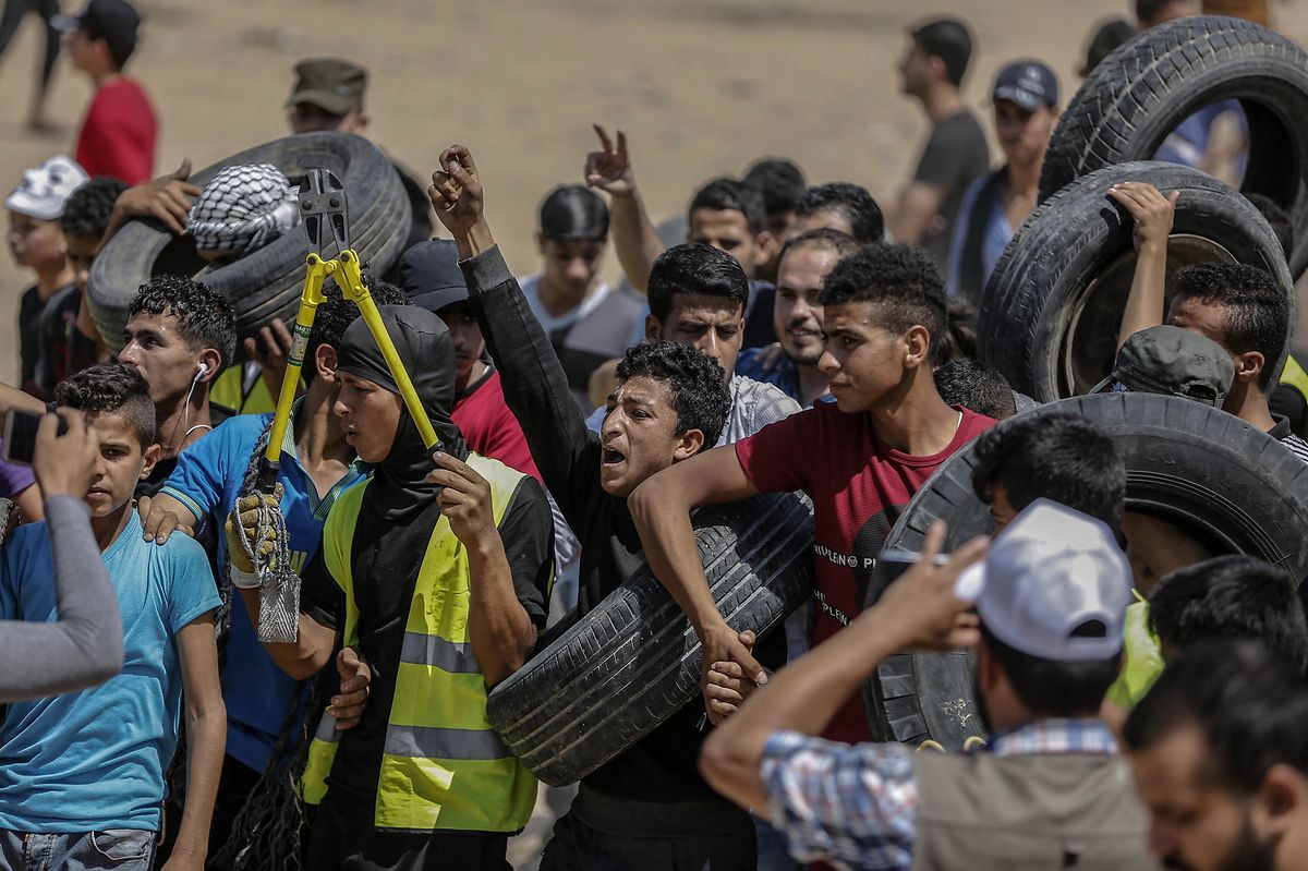Palästinenser tragen Reifen und einen Bolzenschneider während einer Demonstration im Gazastreifen. 