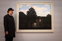 A gallery assistant poses with an artwork entitled 'L'empire des lumieres,1961' by Belgian artist Rene Magritte, during a photocall ahead of a sale of Modern and Contemporary Art, at Sotheby's auction house in London on February 22, 2022. - The artwork is expected to realise in excess of GBP 45 million (EUR 54 million, USD 61million). (Photo by Tolga Akmen / AFP) / RESTRICTED TO EDITORIAL USE - MANDATORY MENTION OF THE ARTIST UPON PUBLICATION - TO ILLUSTRATE THE EVENT AS SPECIFIED IN THE CAPTION