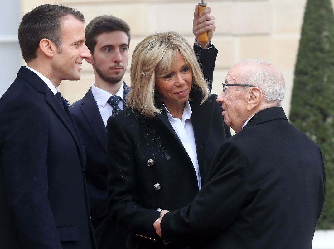 French President Emmanuel Macron (L) and his wife Brigitte Macron welcome Tunisia's President Beji Caid Essebsi at the Elysee Palace in Paris on November 11, 2018 ahead of the start of commemorations marking the 100th anniversary of the 11 November 1918 armistice, ending World War I. (Photo by Jacques Demarthon / AFP)