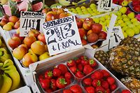 ARCHIV - 24.06.2016, Großbritannien, London: Erdbeeren, Bananen, Ananas, Äpfel und anderes Obstsorten liegen an einem Obststand. Die Preise in britischen Pfund sind auf Schildern zu lesen. (Zu dpa "«Zollbombe»: Handel warnt vor Folgen eines No-Deal-Brexits") Foto: Michael Kappeler/dpa +++ dpa-Bildfunk +++