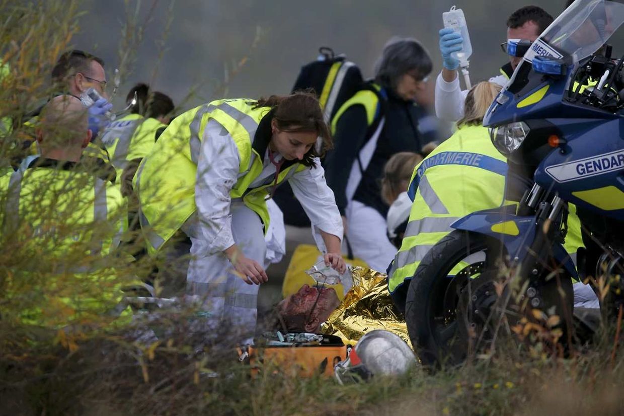 ATTENTION EDITORS - VISUAL COVERAGE OF SCENES OF INJURY    Rescue workers assist a victim near the wreckage of a test TGV train that derailed and crashed in a canal outside Eckwersheim near Strasbourg, eastern France, November 14, 2015.   REUTERS/Vincent Kessler
