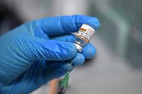 A medical assistant prepares a syringe with the Pfizer BioNTech vaccine for children at a vaccination centre set up at a car dealership in Iserlohn, western Germany, on January 5, 2022, amid the ongoing coronavirus (Covid-19) pandemic. - The owner of the car dealership, Arne Olsen, has temporarily set up a vaccination centre with a team of doctors and nurses at his dealership and has had several hundred people vaccinated since the start in December. As many people as possible are to be vaccinated by the second week of January. (Photo by Ina FASSBENDER / AFP)