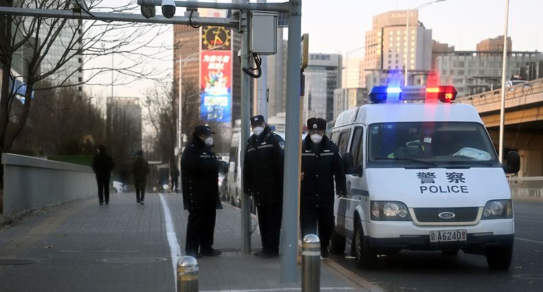 Police keep watch on a road by the Liangma River, where recent protests took place for victims of a deadly fire as well as against China's harsh Covid-19 restrictions, in Beijing on November 29, 2022. - China's major cities of Beijing and Shanghai were blanketed with security on November 29 in the wake of nationwide rallies calling for political freedoms and an end to Covid lockdowns. (Photo by Noel CELIS / AFP)