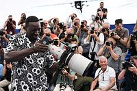 O ator e comediante francês Omar Sy posa com uma máquina fotográfica durante a 75ª edição do Festival de Cinema de Cannes, a 19 de Maio de 2022. 