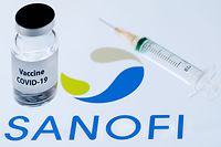 (FILES) This picture taken on November 23, 2020 shows a bottle reading "Vaccine Covid-19" next to French biopharmaceutical company Sanofi logo. - Sanofi will help Pfizer and BioNTech to produce their Covid-19 vaccine and should package more than 100 million doses for the European Union by the end of 2021, the general manager of the French laboratory announced on January 26, 2021 in an interview with Le Figaro. (Photo by JOEL SAGET / AFP)