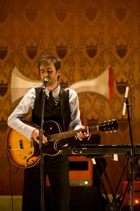 Mann mit Gitarre und professioneller Zwitscherer  