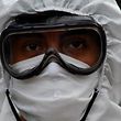 A municipal worker in protective suit prepares to disinfect a car outside a church during the celebration of the day of Saint Christopher, patron saint of travelers and drivers, in Guatemala City on July 30, 2020 amid the COVID-19 -coronavirus pandemic.  (Photo by Johan ORDONEZ / AFP)