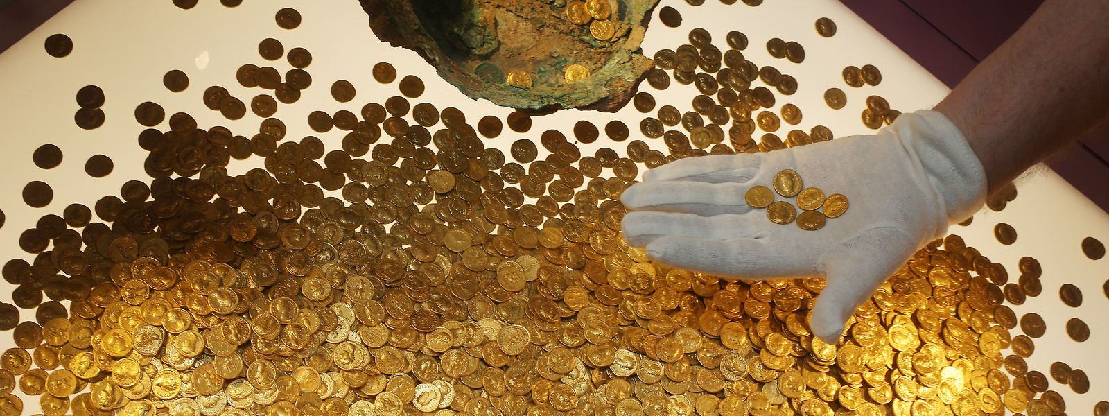 Trier: Der Numismatiker Karl-Josef Gilles platziert im Landesmuseum römische Goldmünzen in einer Vitrine. Es handelt sich um den weltweit größte Goldschatz der römischen Kaiserzeit: 18,5 Kilogramm schwer und rund 2600 Münzen stark. Vor 25 Jahren wurde er in Trier entdeckt.
