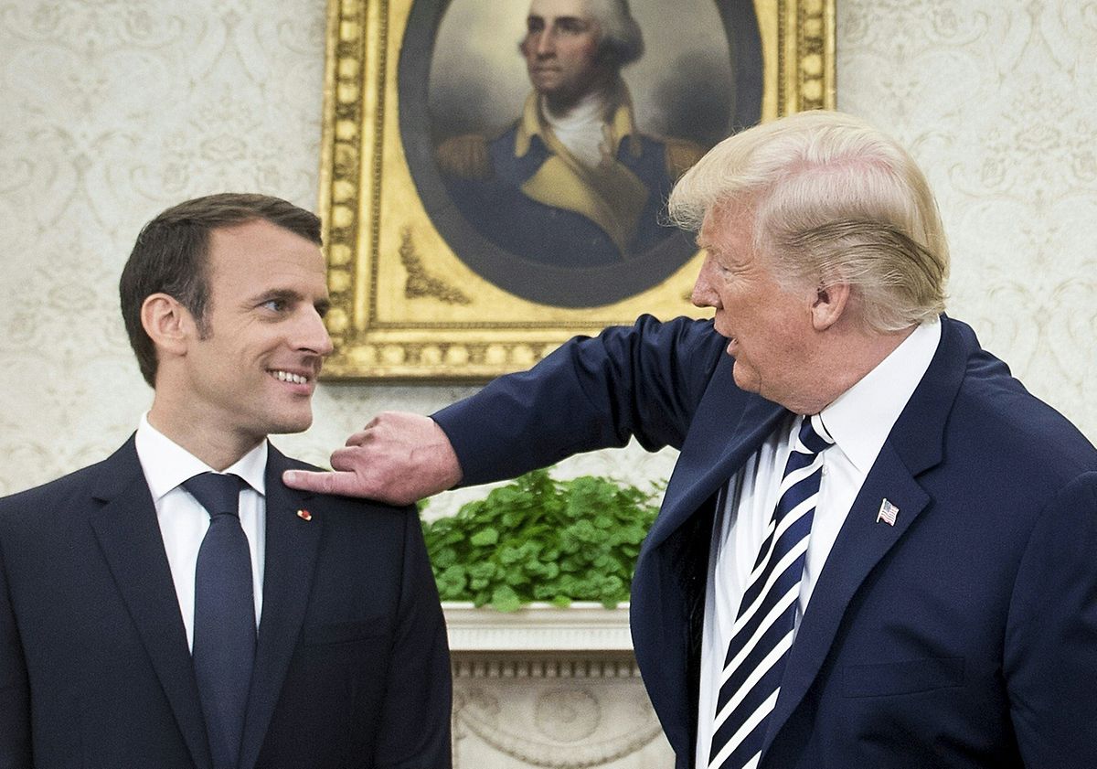 US President Donald Trump clears dandruff from French President Emmanuel Macron's shoulder in the Oval Office Photo: AFP