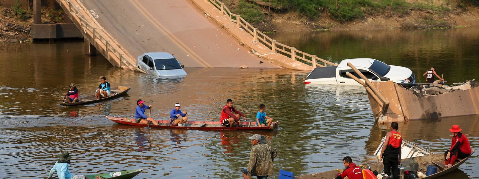 Moradores e equipas de resgate procuram pessoas no rio Curuca após o desabamento de uma ponte em Careiro da Várzea, estado do Amazonas, esta quarta-feira.
