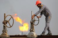 (FILES) In this file photo taken on October 30, 2015, an Iraqi labourer works at an oil refinery in the southern town Nasiriyah. - As crude prices plunge, Iraq's oil sector is facing a triple threat that has slashed revenues, risks denting production and may spell trouble for future exports. (Photo by HAIDAR MOHAMMED ALI / AFP)