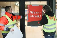16.02.2023, Hamburg: Airport-Mitarbeiter bringen zu Streikbeginn am Flughafen Hamburg ein Plakat mit der Aufschrift "Warnstreik" an. Die Gewerkschaft Verdi hatte angekündigt, in der Tarifauseinandersetzung im öffentlichen Dienst am Freitag sieben Flughäfen ganztägig lahmzulegen. Am Flughafen Hamburg hat der Streik am Donnerstag, 16.02., um 22:00 Uhr begonnen. Foto: Bodo Marks/Bodo Marks/dpa +++ dpa-Bildfunk +++