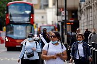 Commuters, some wearing face coverings due to Covid-19, walk outside Victoria Station in central London on June 7, 2021. - The Delta variant of the coronavirus, first discovered in India, is estimated to be 40 percent more transmissible than the Alpha variant that caused the last wave of infections in the UK, Britain's health minister said Sunday. (Photo by Tolga Akmen / AFP)