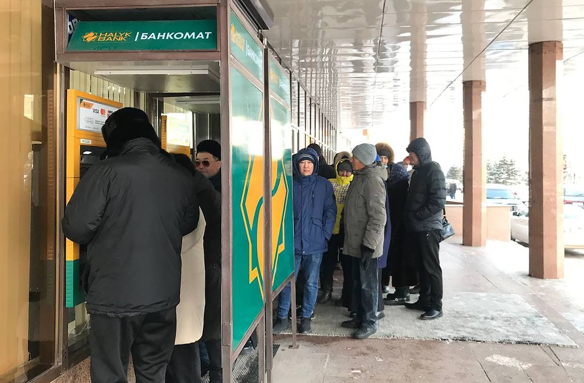 Menschen stehen in der Hauptstadt Nur-Sultan inmitten von Unruhen vor einem funktionierenden Geldautomaten Schlange. 