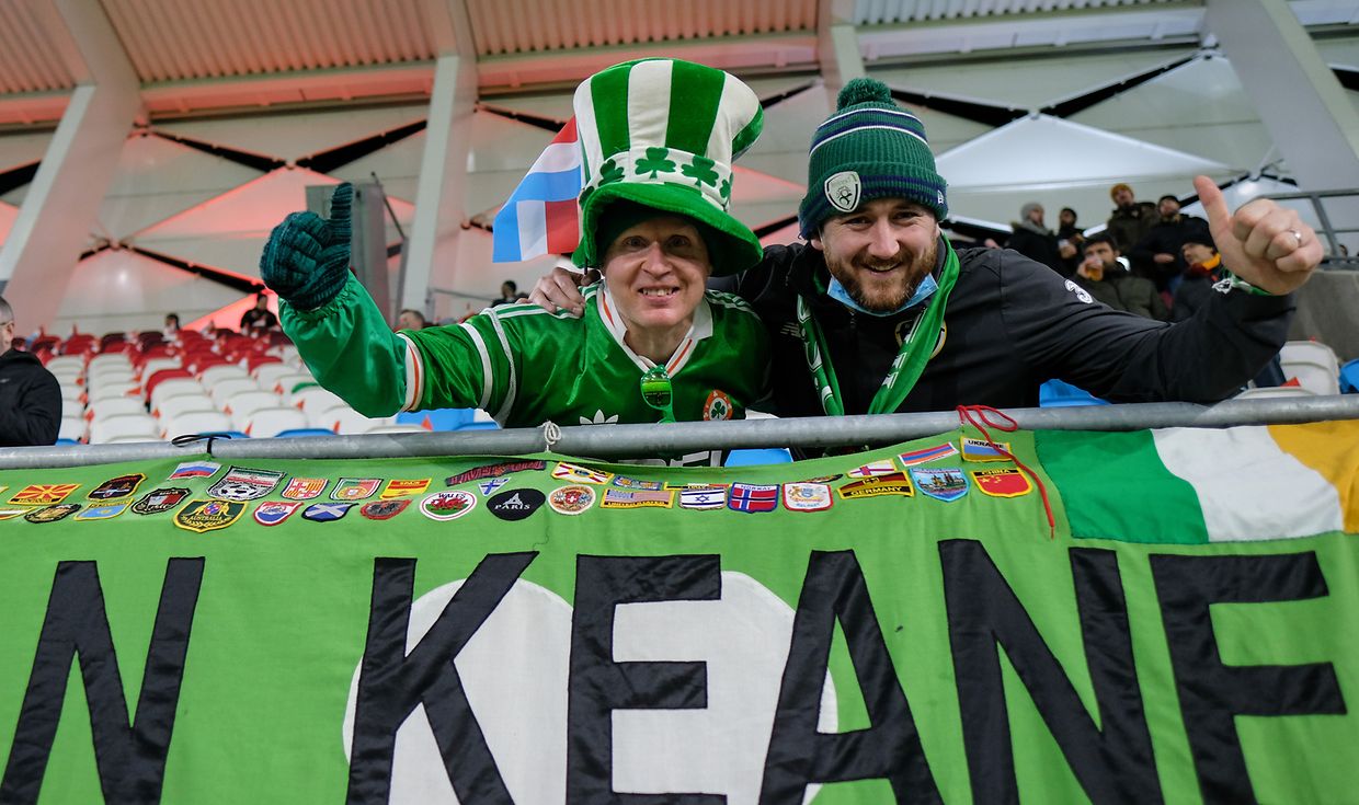 Two Irish fans who traveled with them point fingers at their team.
