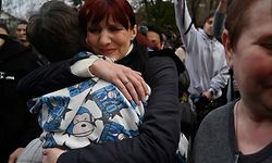 Inessa hugs her son Vitaly after the bus delivering him and more than a dozen other children back from Russian-held territory arrived in Kyiv on March 22, 2023. - More than 16,000 Ukrainian children have been deported to Russia since the February 24, 2022 invasion, according to Kyiv, with many allegedly placed in institutions and foster homes. (Photo by SERGEI CHUZAVKOV / AFP)