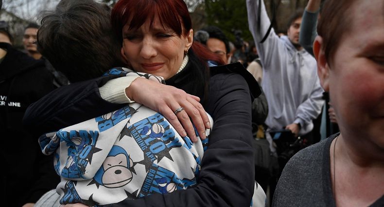 Inessa hugs her son Vitaly after the bus delivering him and more than a dozen other children back from Russian-held territory arrived in Kyiv on March 22, 2023. - More than 16,000 Ukrainian children have been deported to Russia since the February 24, 2022 invasion, according to Kyiv, with many allegedly placed in institutions and foster homes. (Photo by SERGEI CHUZAVKOV / AFP)
