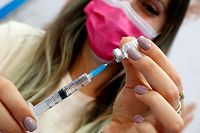 An Israeli health worker administers a dose of the Pfizer-BioNtech Covid-19 vaccine at Clalit Health Services, in a gymnasium in the central Israeli city of Hod Hasharon, on February 4, 2021. - Initial data from Israel's coronavirus vaccination campaign shows the Pfizer/BioNTech jab protects against serious illness, but it is not yet clear whether it slows transmissions or spells progress toward achieving herd immunity, experts say. The Jewish state is carrying out what is widely described as the world's fastest vaccination campaign per capita, watched closely by experts worldwide. (Photo by JACK GUEZ / AFP)