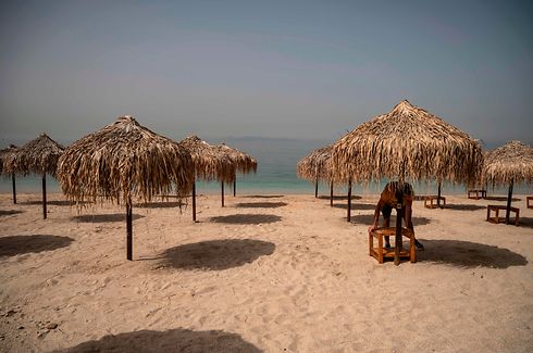 TOPSHOT - This picture shows a beach a day before the official opening of beaches to the public, near Athens on May 15, 2020. - Greece said May 14 it will open 515 beaches strarting May 16 as a balmy weekend approaches, but apply strict social distancing measures owing to the coronavirus. (Photo by Angelos Tzortzinis / AFP)