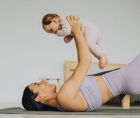 Mother with her baby daughter practice yoga at home