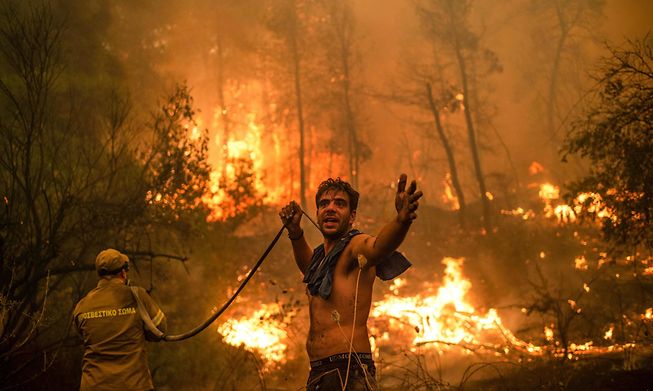 A local resident fought forest fires on Greece's second largest island on Sunday during a heatwave  experts linked to climate change. 