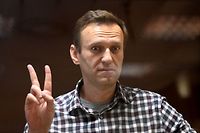 (FILES) In this file photo taken on February 20, 2021 Russian opposition leader Alexei Navalny gestures a V sign from inside a glass cell during a court hearing at the Babushkinsky district court in Moscow. - Russian prosecutors requested om March 15, 2022 that President Vladimir Putin's main political opponent, Alexei Navalny, who is already jailed, serve 13 years in prison on fraud charges. (Photo by Kirill KUDRYAVTSEV / AFP)