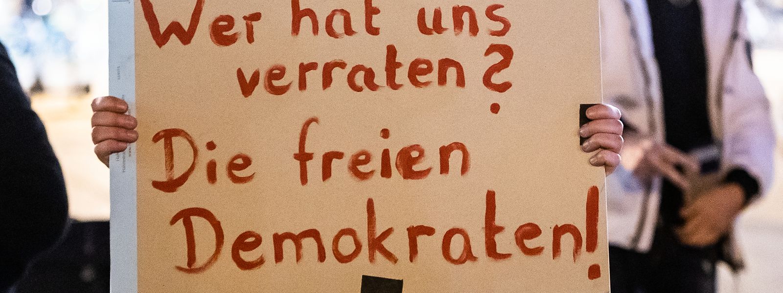 Eine Teilnehmerin hält bei der Demonstration gegen die Wahl des neuen Ministerpräsidenten von Thüringen ein Plakat hoch.