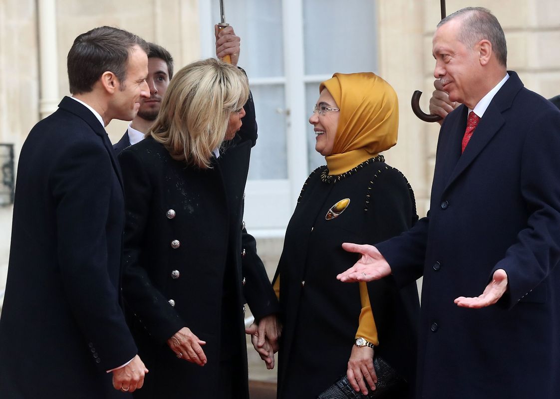 Turkish President Recep Tayyip Erdogan (R) and his wife Emine Erdogan (2ndR) are welcomed by French President Emmanuel Macron (L) and his wife Brigitte Macron as they arrive at the Elysee Palace in Paris on November 11, 2018 ahead of the start of commemorations marking the 100th anniversary of the 11 November 1918 armistice, ending World War I. (Photo by Jacques Demarthon / AFP)