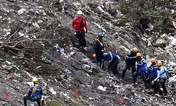 Investigators work near scattered debris while making their way through the crash site of the Germanwings Airbus A320 that crashed in the French Alps above the southeastern town of Seyne. The young co-pilot of the doomed Germanwings flight that crashed on March 24, appears to have "deliberately" crashed the plane into the French Alps after locking his captain out of the cockpit, but is not believed to be part of a terrorist plot, French officials said on March 26, 2015. AFP PHOTO / ANNE-CHRISTINE POUJOULAT