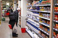 A customer looks at an information note while shopping in a supermarket in Budapest's 12th district on February 1, 2022, as the government announced a price stop for several basic foods. - Hungarian Prime Minister Orban had announced price controls from February 1 on several common grocery items in response to rising inflation. The price control is effective until May 1, 2022. (Photo by ATTILA KISBENEDEK / AFP)