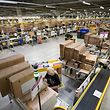 Sitz in Luxemburg, Kunden in ganz Europa: Mitarbeiter bereiten beim Onlinehändler Amazon Artikel für den Versand vor.