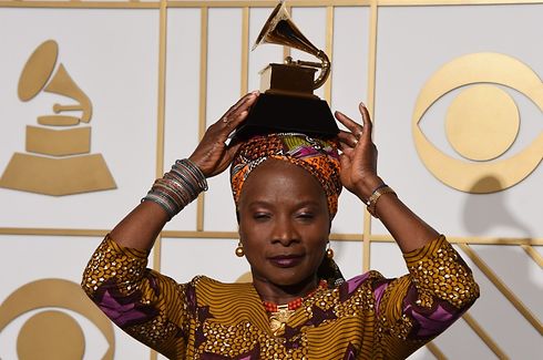 Angelique Kidjo poses with her Best World Music Album trophy for "Sings" in the press room during the 58th Annual Grammy Music Awards in Los Angeles on February 15, 2016.  AFP PHOTO / MARK RALSTON