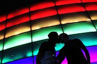 TOPSHOT - Camilo Barato and Cristian Toquica kiss the Movistar Arena coloured with the rainbow flag during the International LGBTIQ Pride Day in Bogota, Colombia on June 28, 2021. (Photo by DANIEL MUNOZ / AFP)