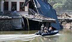 Military personnel on an inflatable boat ship past a destroyed house on the Ahr river in Rech, Rhineland-Palatinate, western Germany, on July 21, 2021, after devastating floods hit the region. (Photo by Christof STACHE / AFP)