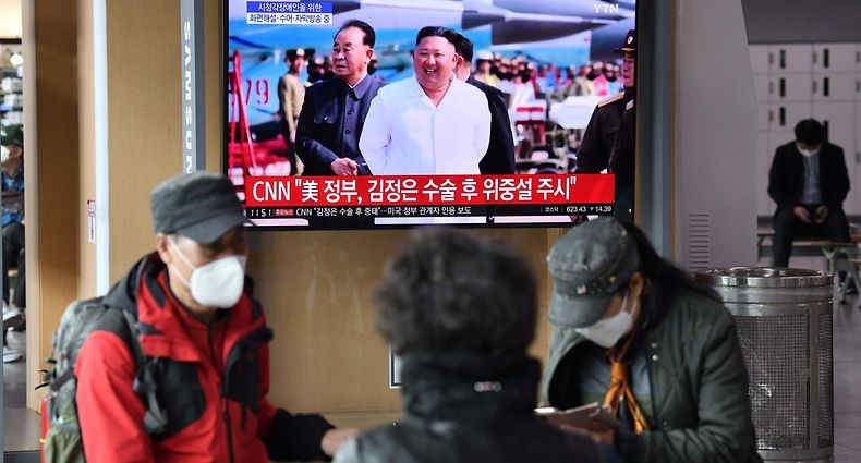 People watch a television news broadcast showing file footage of North Korean leader Kim Jong Un, at a railway station in Seoul on April 21, 2020. - South Korea played down a report on April 21 that the North's leader Kim Jong Un was being treated after surgery, as speculation mounted over his absence from a key anniversary. (Photo by Jung Yeon-je / AFP)