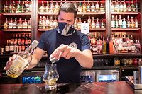 ARCHIV - 15.07.2020, Großbritannien, Edinburgh: Barkeeper Dejah Hajdukovic serviert einen Whisky im Pub «The Piper's Rest». Pubs, Cafés und Restaurants dürfen nach den Plänen der Regionalregierungen in beiden britischen Landesteilen wieder öffnen. Foto: Jane Barlow/PA Wire/dpa +++ dpa-Bildfunk +++
