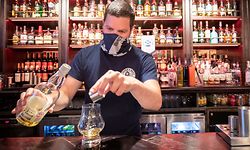 ARCHIV - 15.07.2020, Großbritannien, Edinburgh: Barkeeper Dejah Hajdukovic serviert einen Whisky im Pub «The Piper's Rest». Pubs, Cafés und Restaurants dürfen nach den Plänen der Regionalregierungen in beiden britischen Landesteilen wieder öffnen. Foto: Jane Barlow/PA Wire/dpa +++ dpa-Bildfunk +++