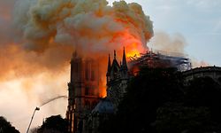 A firefighter uses a hose to douse flames and smoke billowing from the roof at Notre-Dame Cathedral in Paris on April 15, 2019. - A fire broke out at the landmark Notre-Dame Cathedral in central Paris, potentially involving renovation works being carried out at the site, the fire service said.Images posted on social media showed flames and huge clouds of smoke billowing above the roof of the gothic cathedral, the most visited historic monument in Europe. (Photo by GEOFFROY VAN DER HASSELT / AFP)