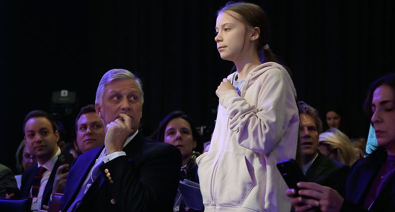 Swedish climate activist Greta Thunberg (C) walks past King Philippe of Belgium (L) prior to a session at the Congress center during the World Economic Forum (WEF) annual meeting in Davos, on January 21, 2020. (Photo by Fabrice COFFRINI / AFP)