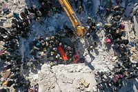 TOPSHOT - An aerial picture shows rescuers searching the rubble of buildings for casualties and survivors in the village of Salqin in Syria's rebel-held northwestern Idlib province at the border with Turkey  following an earthquake, on February 7, 2023. (Photo by Omar HAJ KADOUR / AFP)