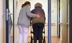 A elderly care nurse helps a resident in the retirement home St. Barbara of German welfare organisation in Stuttgart, southern Germany, on November 17, 2020, amid the new coronavirus COVID-19 pandemic. (Photo by THOMAS KIENZLE / AFP)