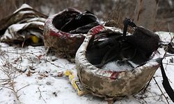 This photograph shows helmets of Ukrainian servicemen with blood stains on a road side while medics of Ukrainian Army evacuate wounded soldiers on a road not far of Soledar, Donetsk region on January 14, 2023, amid the Russian invasion of Ukraine. - Ukraine reported a fresh wave of attacks and hits on key infrastructure facilities on January 14, 2023, a day after Russia claimed to have captured the ravaged eastern town of Soledar following a long battle. (Photo by Anatolii Stepanov / AFP)
