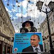 An activist distributes election leaflets in support of presidential candidate, President Vladimir Putin on a street in downtown Moscow on March 16, 2018.
Russia will vote for president on March 18, 2018. / AFP PHOTO / Yuri KADOBNOV