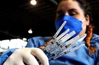A nurse prepares booster doses of the AstraZeneca's COVID-19 vaccine for people over 50 years old at a vaccination center set up at the Benito Juarez Auditorium in Zapopan, state of Jalisco, Mexico, on January 24, 2022. (Photo by ULISES RUIZ / AFP)