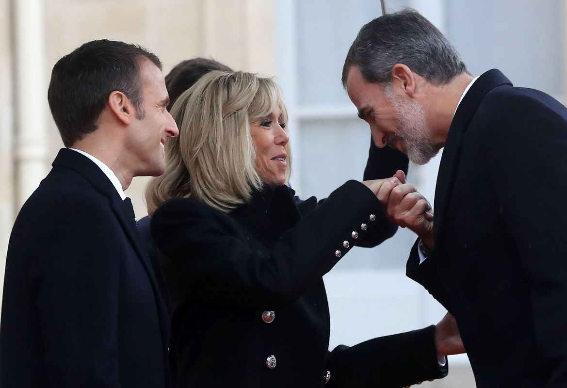 French President Emmanuel Macron (L) and his wife Brigitte Macron welcome Spain's King Felipe VI as he arrives at the Elysee Palace in Paris on November 11, 2018 ahead of the start of commemorations marking the 100th anniversary of the 11 November 1918 armistice, ending World War I. (Photo by Jacques Demarthon / AFP)